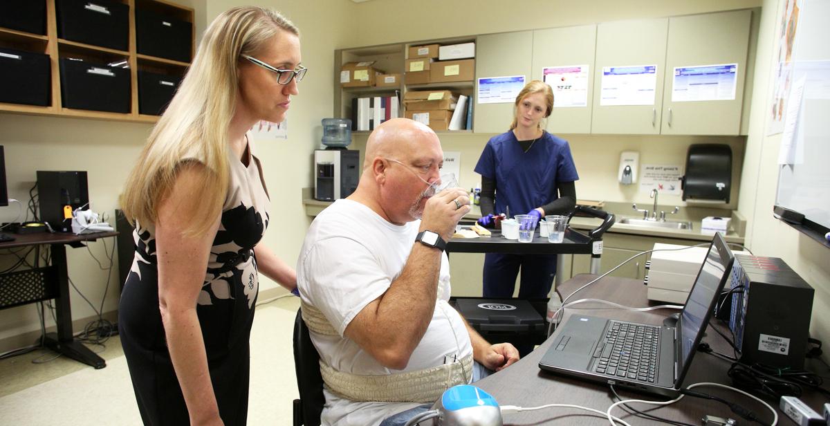 Dr. Kendrea加仑, 帕特·卡普斯·柯维联合卫生专业学院语言病理学助理教授, 与一名志愿者一起收集吞咽数据，对照从ALS患者那里收集的数据. 她的研究目标是改善那些患有吞咽困难的人的治疗选择.