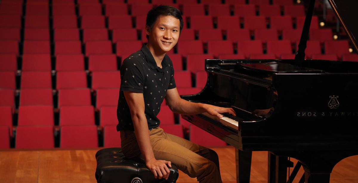 十大彩票网投平台的学生Paul Nguyen站在校园莱德劳表演艺术中心的钢琴前.