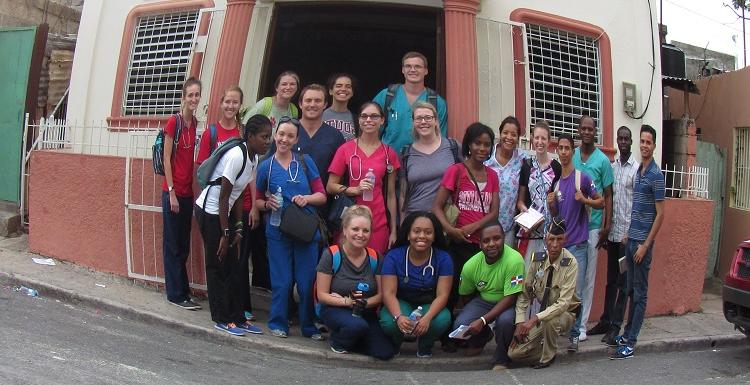 美国护理专业学生, 和平基金会的工作人员和其他人聚集在洛斯米纳社区一个用作诊所的教堂外.